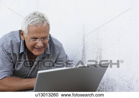 Senior man looking at laptop View Large Photo Image Stock Image - Senior man looking at laptop. Fotosearch