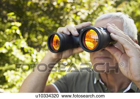 Senior man looking through binoculars View Large Photo Image Stock Image - Senior man looking through binoculars. Fotosearch