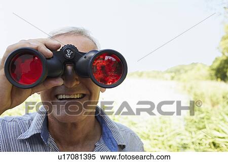 Stock Photography - Senior man looking through field glass. Fotosearch