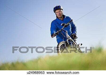 Senior man pushing mountain bike View Large Photo Image Stock Image - Senior man pushing mountain bike. Fotosearch