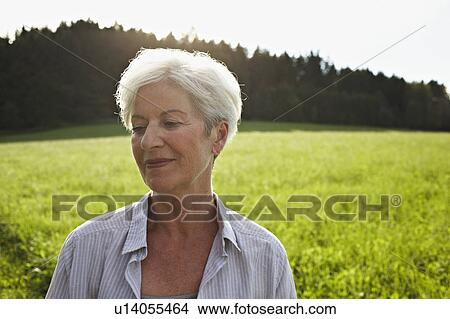 Picture - Senior woman in meadows. Fotosearch