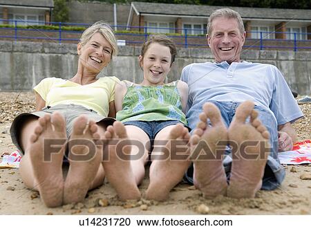 Stock Image - Seniors and granddaughter on beach. Fotosearch
