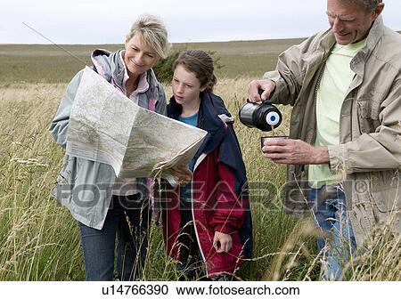 Stock Image - Seniors and granddaughter pause on walk. Fotosearch