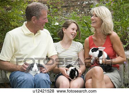 Stock Photo - Seniors and granddaughter with pets. Fotosearch