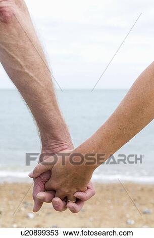 Seniors hold hands on beach View Large Photo Image Stock Image - Seniors hold hands on beach. Fotosearch