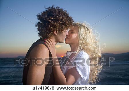 Stock Photo - Sexy cple kiss at sunset. Fotosearch