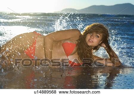 Stock Photo - Sexy woman lays on beach portrait. Fotosearch