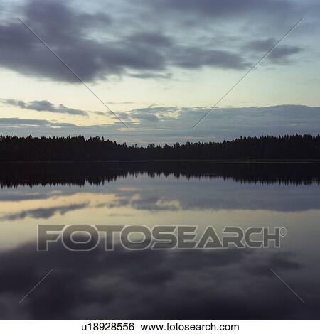 Sky and trees reflected in lake at night View Large Photo Image Stock Photograph - Sky and trees reflected in lake at night. Fotosearch
