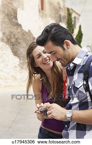 Smiling couple checking snapshots View Large Photo Image Stock Photograph - Smiling couple checking snapshots. Fotosearch