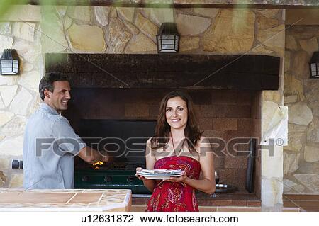Smiling couple standing by barbeque View Large Photo Image Stock Image - Smiling couple standing by barbeque. Fotosearch