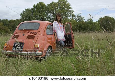 Smiling female with car in field View Large Photo Image Stock Photograph - Smiling female with car in field. Fotosearch