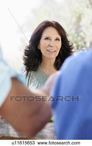 Smiling older woman looking at family View Large Photo Image Stock Image - Smiling older woman looking at family. Fotosearch