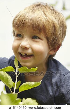 Stock Image - Smiling young boy in nature. Fotosearch