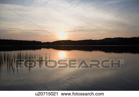 Stock Image - Sunset over a lake. Fotosearch