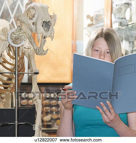 Stock Photo - Teenage looking at exercise book. Fotosearch