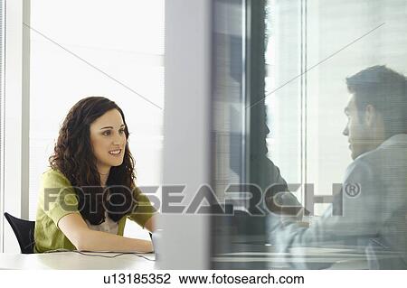 Stock Image - Three people in a meeting. Fotosearch