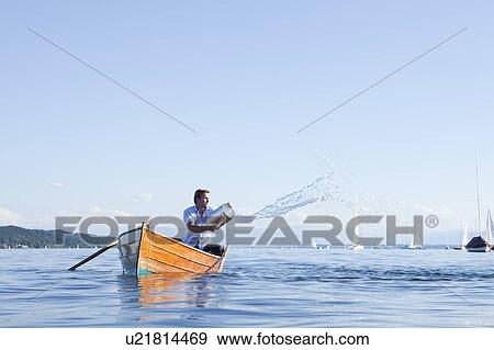 Stock Photo - Throwing buckets of water ot ouf boat. Fotosearch