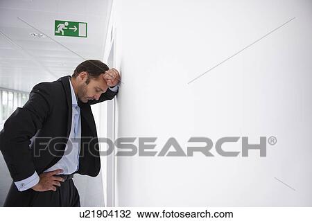 Stock Image - Tired businessman in an empty office. Fotosearch