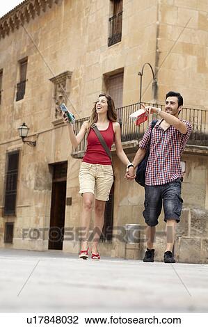 Tourist couple exploring town square View Large Photo Image Stock Image - Tourist couple exploring town square. Fotosearch