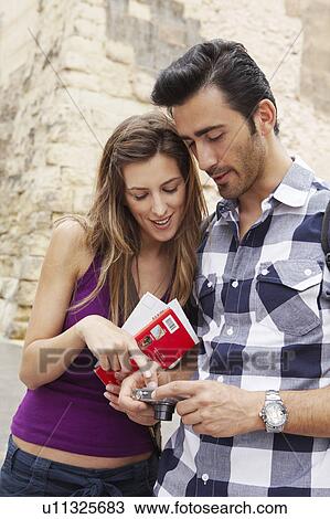 Stock Image - Tourists checking their pictures. Fotosearch