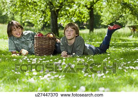 Two boys resting in meadow View Large Photo Image Stock Image - Two boys resting in meadow. Fotosearch