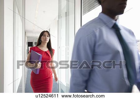 Stock Image - Two business people walking past camera. Fotosearch
