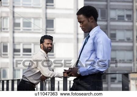 Two businessmen thinking before work View Large Photo Image Stock Image - Two businessmen thinking before work. Fotosearch