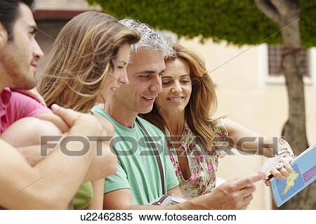 Two couples looking at postcard View Large Photo Image Stock Photography - Two couples looking at postcard. Fotosearch