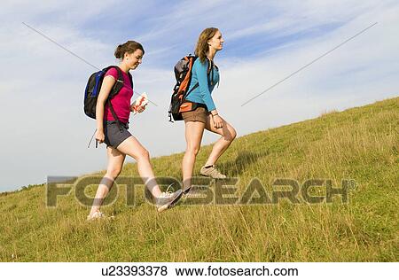 Two hikers climb hill View Large Photo Image Stock Photo - Two hikers climb hill. Fotosearch