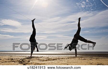 Two people cartwheeling on beach View Large Photo Image Stock Image - Two people cartwheeling on beach. Fotosearch