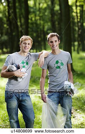 Two young men collecting trash in woods View Large Photo Image Stock Photo - Two young men collecting trash in woods. Fotosearch