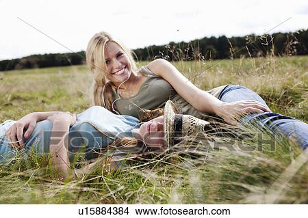 Two young women laying in grass View Large Photo Image Picture - Two young women laying in grass. Fotosearch