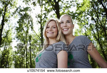 Picture - Two young women leaning together. Fotosearch