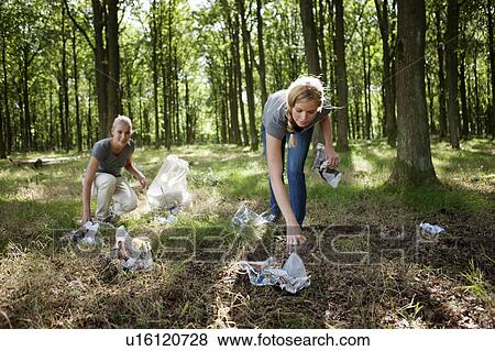 Two young women picking up trash View Large Photo Image Stock Photo - Two young women picking up trash. Fotosearch