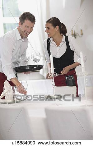 Waiter and waitress laying the table View Large Photo Image Stock Image - Waiter and waitress laying the table. Fotosearch