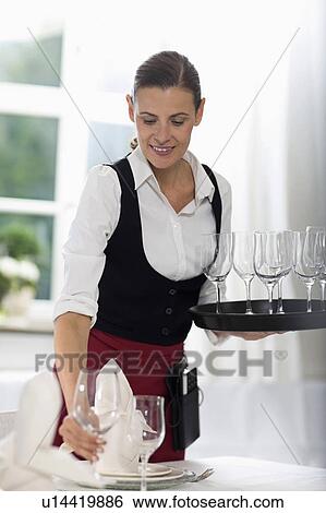 Stock Photograph - Waitress laying the table. Fotosearch