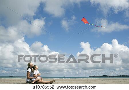 Woman and daughter flying a kite View Large Photo Image Stock Image - Woman and daughter flying a kite. Fotosearch