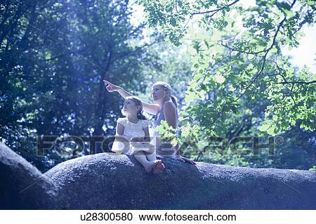 Stock Image - Woman and daughter in forest. Fotosearch