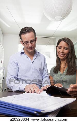 Woman and man doing paperwork at home View Large Photo Image Picture - Woman and man doing paperwork at home. Fotosearch
