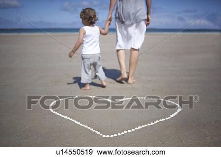Stock Photo - Woman and son in front on the beach. Fotosearch