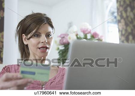 Stock Image - Woman at laptop with credit card. Fotosearch