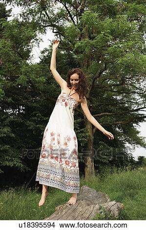 Picture - Woman balancing on trunk. Fotosearch
