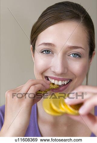 Woman bites on gold coins View Large Photo Image Stock Photo - Woman bites on gold coins. Fotosearch