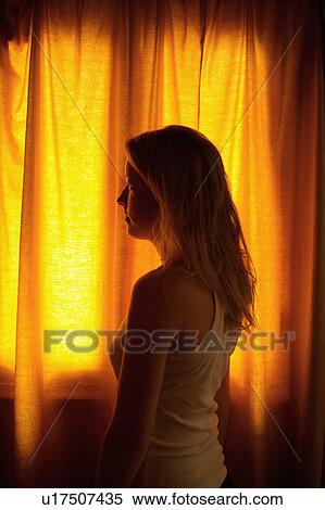 Woman by window, curtains drawn View Large Photo Image Stock Photography - Woman by window, curtains drawn. Fotosearch