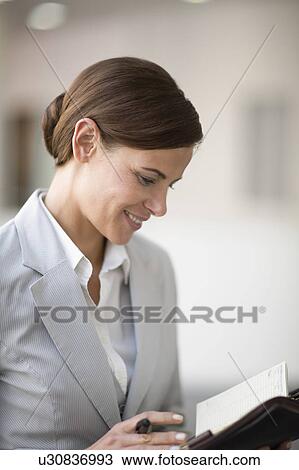 Woman checking her date book View Large Photo Image Stock Image - Woman checking her date book. Fotosearch