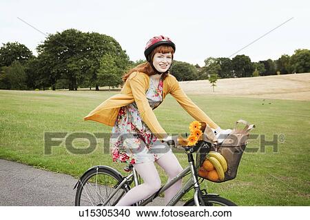 Woman cycling in park View Large Photo Image Stock Image - Woman cycling in park. Fotosearch