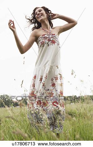 Stock Image - Woman dancing in wild meadow. Fotosearch