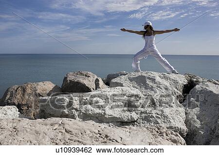 Stock Image - Woman doing sports on rocks. Fotosearch