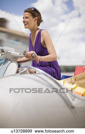 Woman driving a vespa View Large Photo Image Stock Photo - Woman driving a vespa. Fotosearch