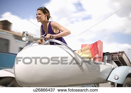 Stock Photo - Woman driving a vespa. Fotosearch